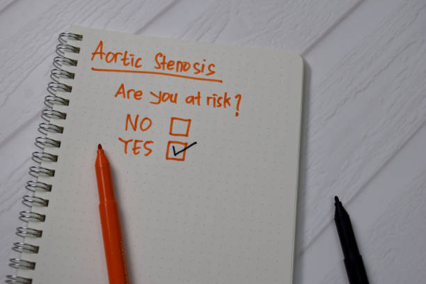 istock Aortic Stenosis, Are You At Risk? write on a book. Supported by an additional services isolated wooden table. 1272316704