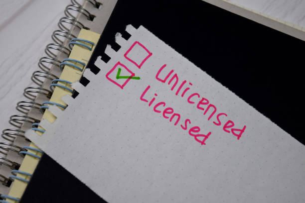 istock Unlicensed and Licensed write on a book. Supported by an additional services isolated wooden table. 1272316732