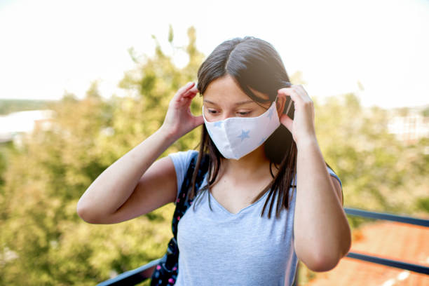 istock Caucasian girl putting on face personal protective face mask. 1272319250