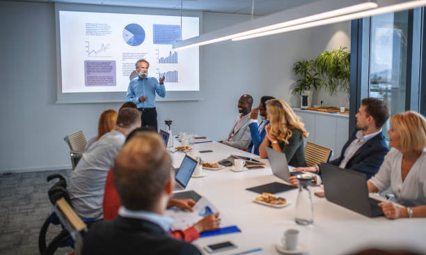 istock Mature Businessman Making Presentation to Executive Team 1272326800