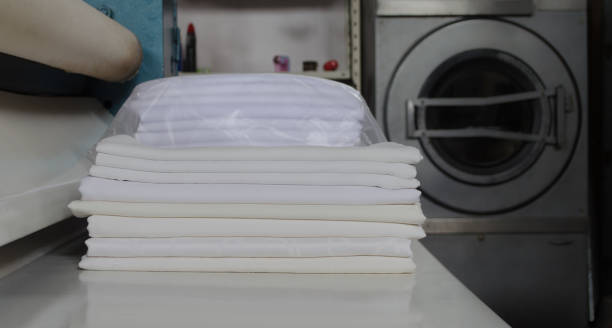 istock Stack of folded white fabrics in an industrial laundry. Laundry service for companies, industries and institutions. 1272326835