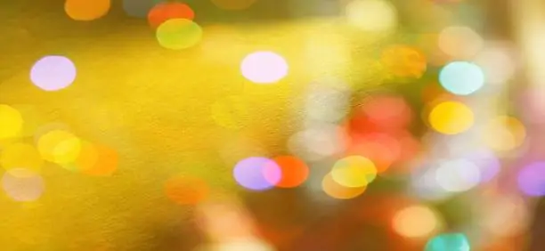 Photo of Festive warm background or greeting card. Sun glare on a bright yellow background. The nuances of orange, yellow, pink, lilac, beige and white. Beautiful bokeh effect