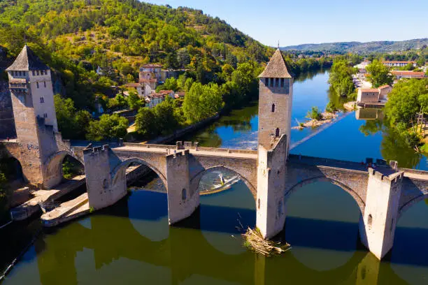 Scenic aerial view of medieval arched Valentre bridge across Lot River in French commune of Cahors on summer day