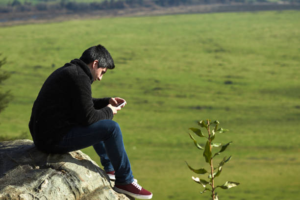 istock young man sitting from the top using his phone 1272330521