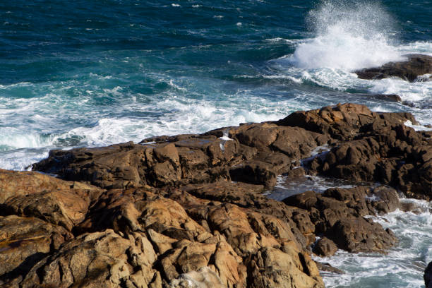 waves with white foam breaking over brown rocks on the coast of A Coruña in Spain