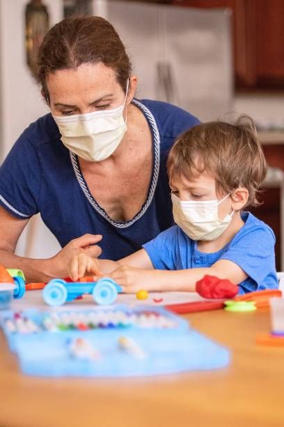 istock Child boy learning with colorful clays using face masks while locked down because pandemic 1272332067