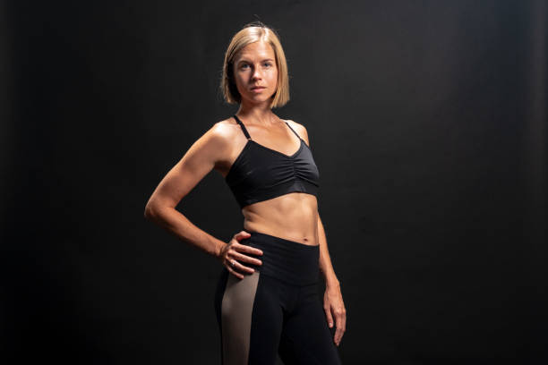 istock Blonde athlete in workout clothing stretches and warms up. 1272332282