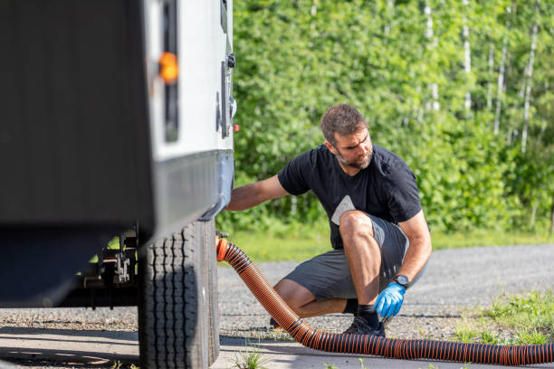 istock Man Emptying RV Sewer at Dump Station After Camping 1272334299