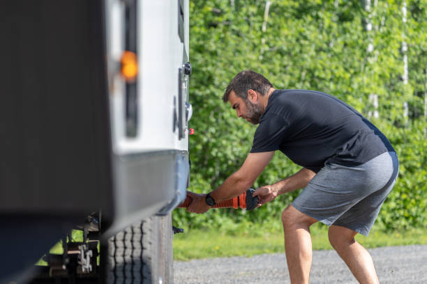 istock Man Emptying RV Sewer at Dump Station After Camping 1272334317