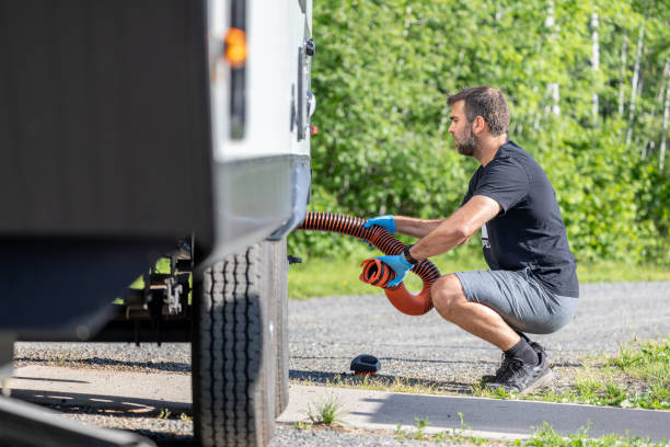 istock Man Emptying RV Sewer at Dump Station After Camping 1272334350