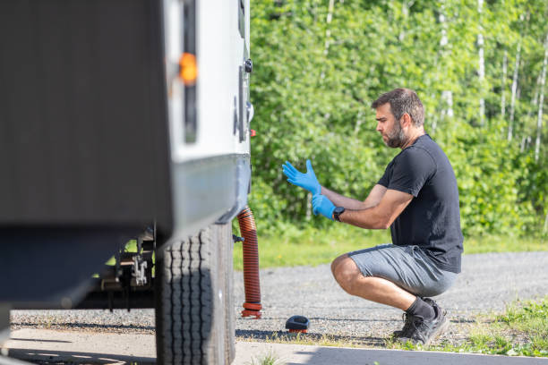 istock Man Emptying RV Sewer at Dump Station After Camping 1272334359