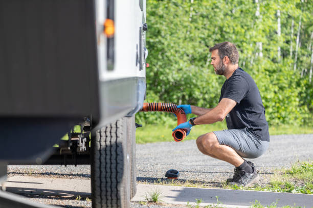 istock Man Emptying RV Sewer at Dump Station After Camping 1272334371