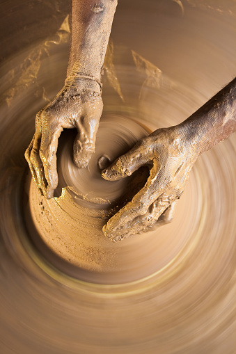 A image with top view showing the hands of a craftsman. For getting the blur in background I used a slow shutter speed 1/15sec giving not so sharp image. I used a strobe on bottom left corner. The lit area looks in focus than other side.