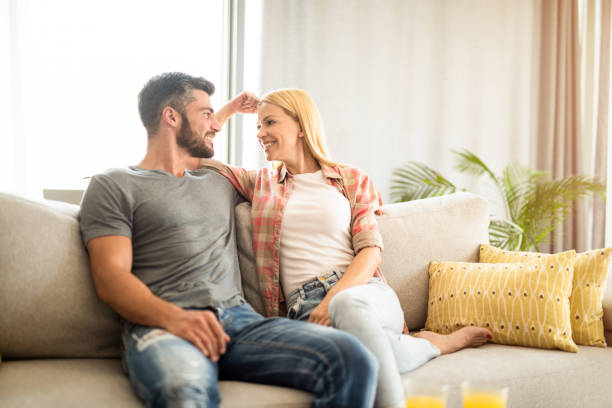 istock Happy young couple relaxing together on sofa. 1272341797