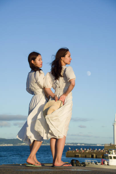 Two women watching the sunset from a sunset spot along the coast