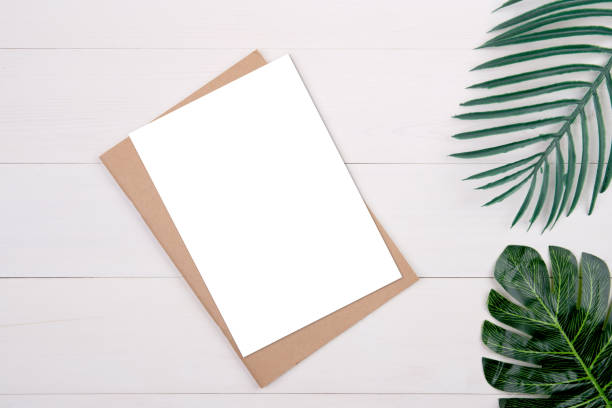 istock Blank paper sheet copy space with mockup and leaf on wooden table, poster and notebook, postcard decoration your design or branding, simplicity and minimal, nobody, flat lay, top view. 1272344354