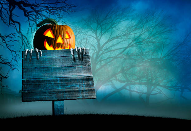 istock Jack O'Lantern Peeking Out From Behind Old Weathered Sign 1272345918