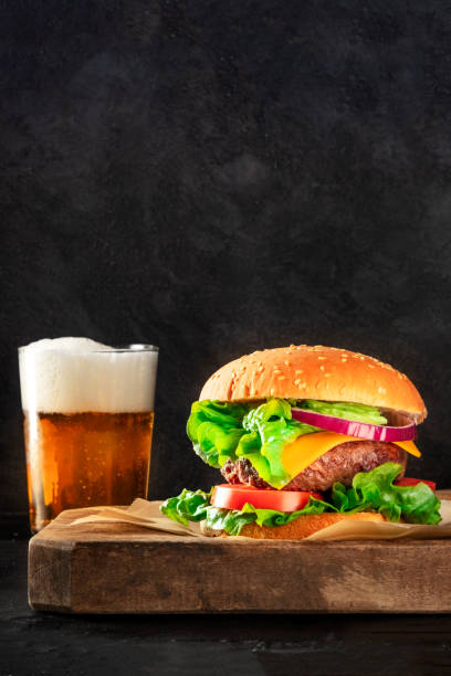 istock Burger and beer, a side view on a dark background with copy space 1272345969