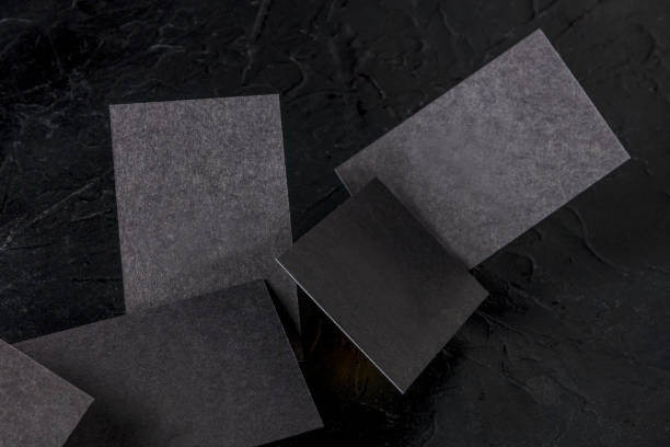istock Thick black business cards, floating on a black background, a mockup 1272346069