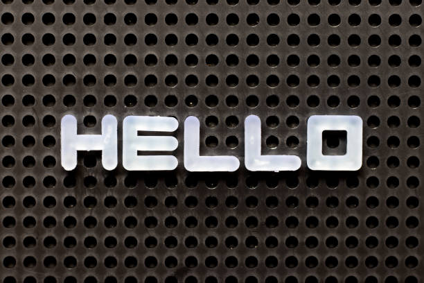 istock White color alphabet with word hello on black pegboard background 1272346646