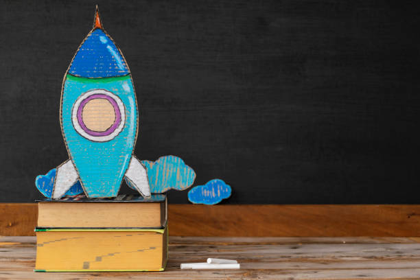 istock A paper rocket placed on a book, the background is a blackboard and chalk. Back to school concept 1272350557
