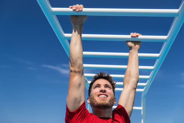 macaco fitness barra homem treinando músculos de braços em academia da selva ao ar livre no verão. atleta trabalhando em escalada emocionante em equipamentos de escada no centro de atletismo esportivo. - crossfit exercising sports training outdoors - fotografias e filmes do acervo