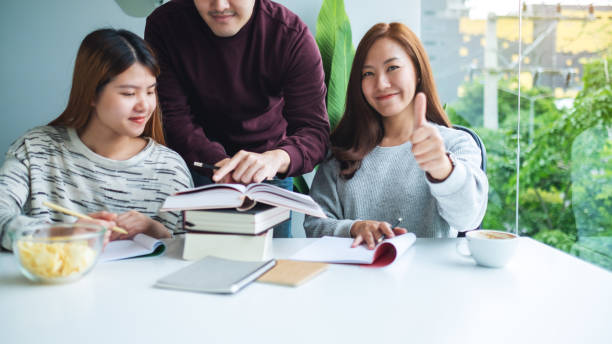 istock A female student making thumb up hands sign while tutoring and catching up workbook 1272355096