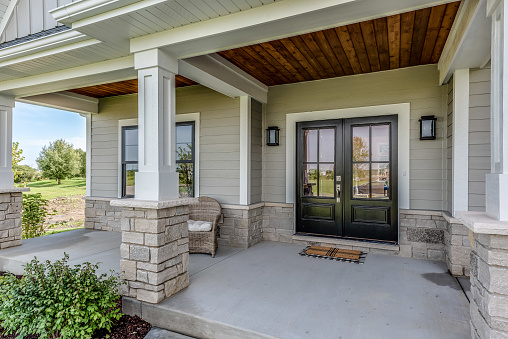 Siding, wood and stone make up the initial front entrance to the home