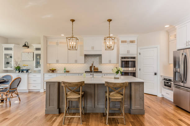 Two pendant lights hang over kitchen island New hardwood flooring in kitchen with new bottom freezer refrigerator home addition photos stock pictures, royalty-free photos & images