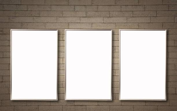 istock Row of three vertical mock-up blank poster frames on a stone wall. 1272361603