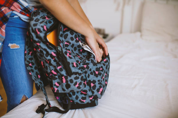 istock School girl putting school supplies into backpack 1272365177