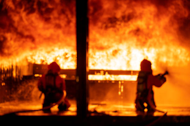 istock Blurred background Firefighters use water fog spraying down fire flame in building. 1272366503