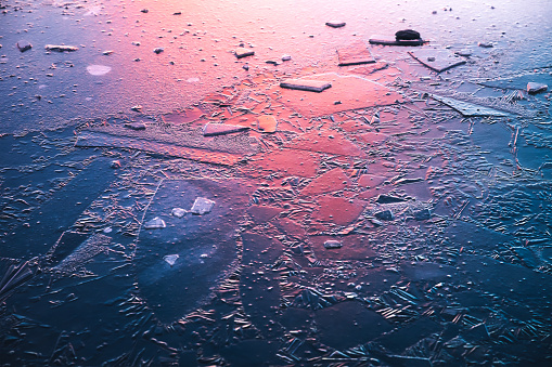 Idyllic frozen lake illuminated by the colorful morning sunlight.