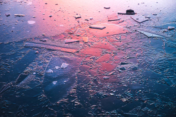 Frozen Lake At Sunrise Idyllic frozen lake illuminated by the colorful morning sunlight. frozen water stock pictures, royalty-free photos & images