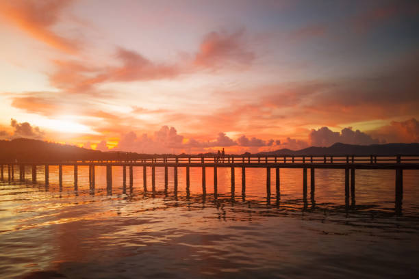 istock Couple walking on look Sunset wooden bridge. 1272369175