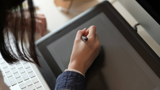 istock Female designer drawing on graphic tablet in office room 1272369935