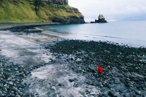 Man in Talisker Bay Beach in Scotland, UK.