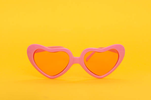 istock Pink heart shaped sunglasses on a yellow background 1272372358