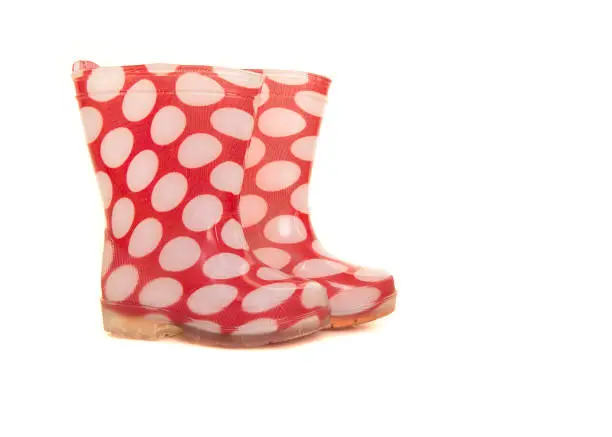 Red and white polka dotted rainboots for kids isolated on a white background