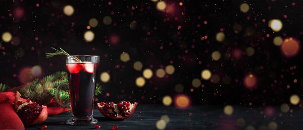 로즈마리, 샴페인, 보케 조명이 있는 검은 테이블에 클럽 소다를 곁들인 석류 크리스마스 칵테일. 자마 음료. - branch glass wine berry fruit 뉴스 사진 이미지