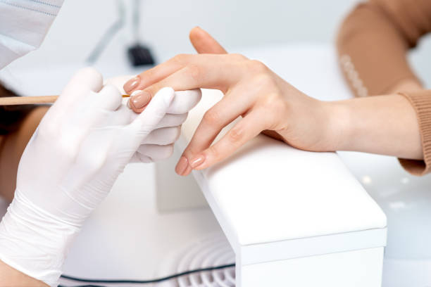 istock Manicure master applying beige nail polish 1272374828