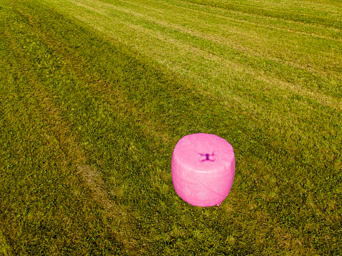 Ensilage packages with a drone shadow. Swedish Pink Ribbon organisation for breast cancer awareness campaigned together with swedish farmers to pack ensilage in pink plastic.