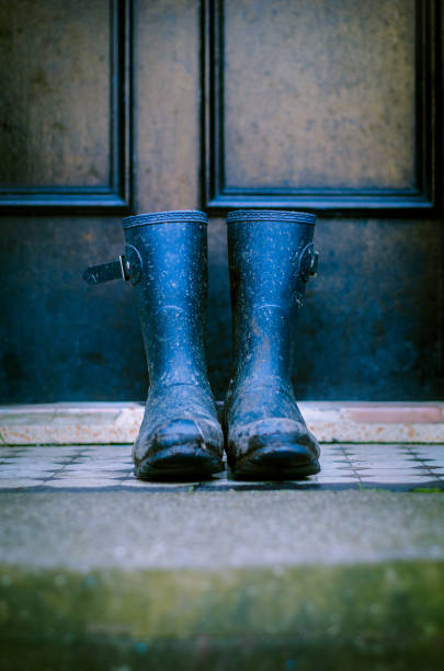 dirty muddy rain boots outside on a front door step - wet places imagens e fotografias de stock