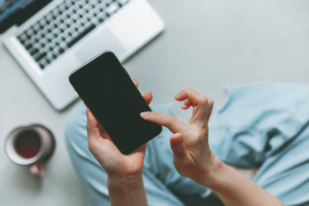 istock Woman using smartphone to work at home during isolation 1272379185