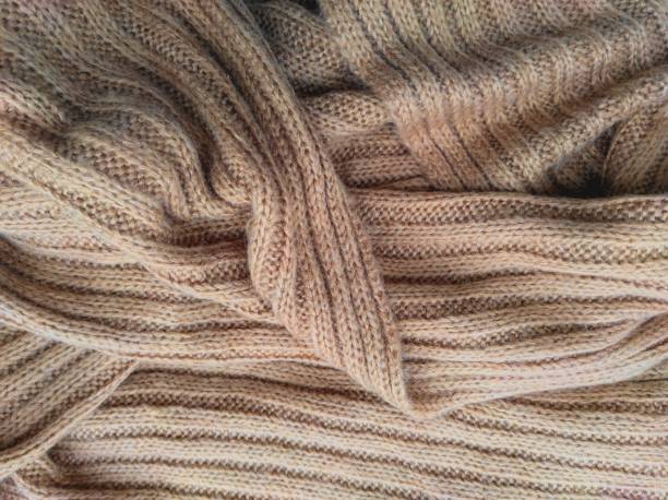 beige gestrickte schal oder pullover zerknittert, nahaufnahme. textur hintergrund von warm gehäkelten kleidungsstück textil. strickwaren stoff. - chunky jewelry stock-fotos und bilder