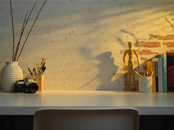 istock Study table with copy space, books, camera ad school elements in living room 1272380134