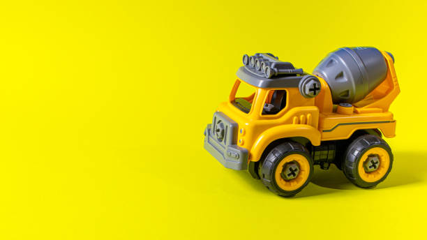 istock Orange concrete mixer toy typewriter on a yellow background. 1272380227