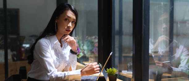 istock Portrait of female worker looking into camera while online working in cafe 1272381219