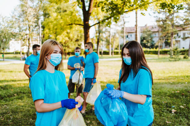 istock Volunteers with garbage bags cleaning up garbage outdoors - ecology concept. 1272381748
