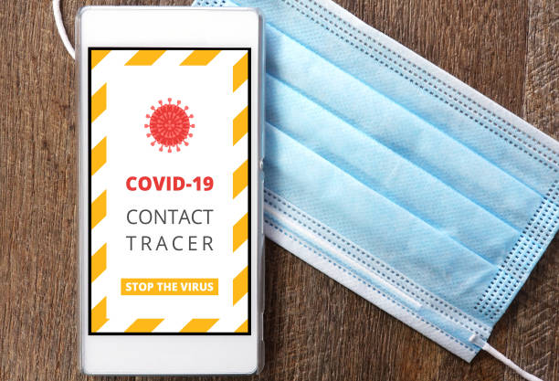 Covid-19 contact tracer app on smart phone with face mask Covid-19 contact tracer app on smart phone with face mask tracing stock pictures, royalty-free photos & images